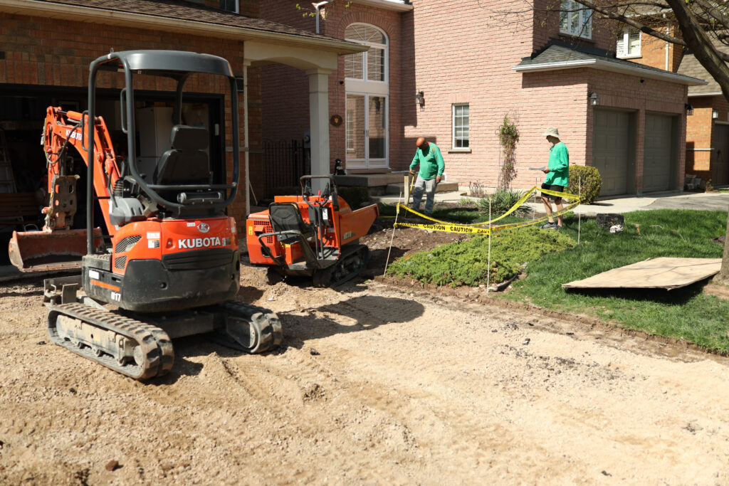 Contractors preparing a driveway for installing interlocked stone.
