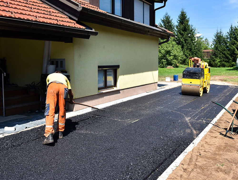 Contractors in the process of installing an asphalt driveway