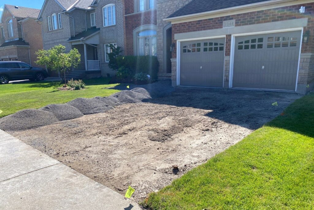 Driveway with asphalt removed revealing the gravel underneath