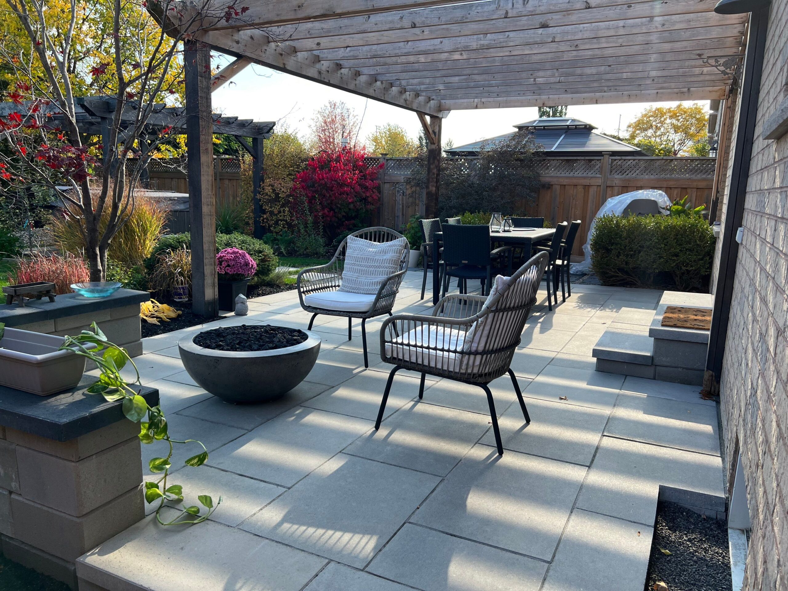 Modern Patio Slabs With Fire Feature Under a Pergola